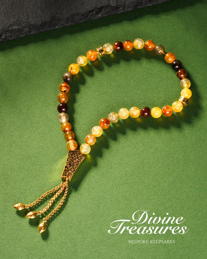 A multicolored beaded tasbeeh with a gold chain tassel
