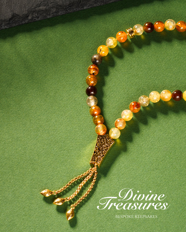 A multicolored beaded tasbeeh with a gold chain tassel